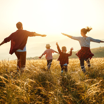 familie läuft durchs feld im sonnenuntergang